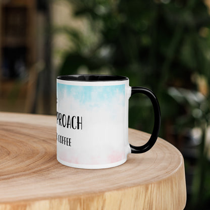 Mug with 'Do not approach while drinking coffee' text on a wooden surface with a blurred green background