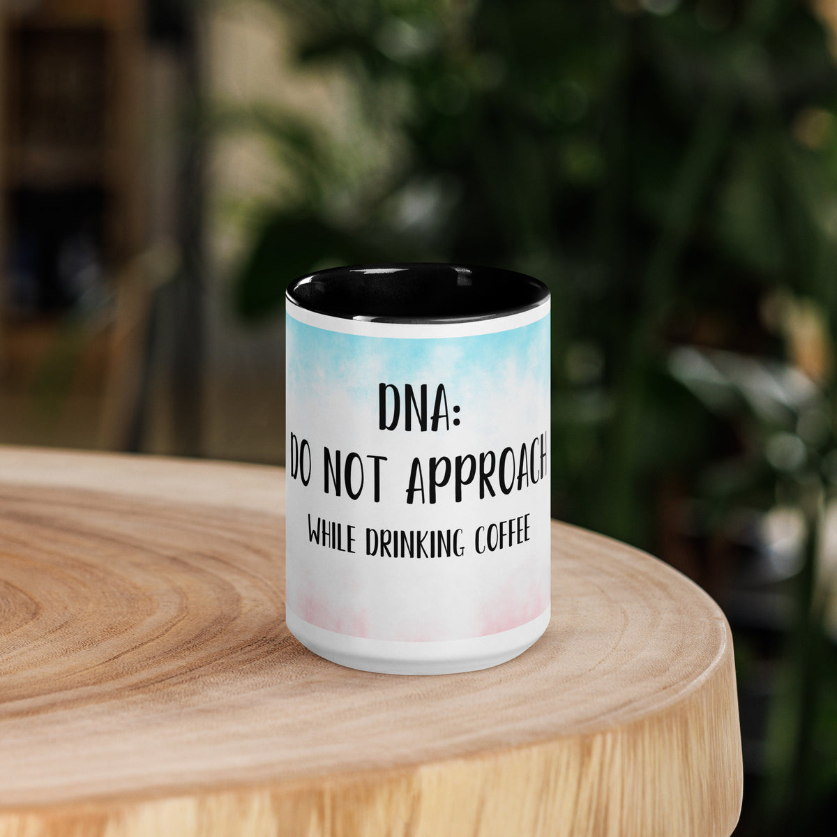 Mug with 'do not approach while drinking coffee' logo on a wooden surface with a blurred background