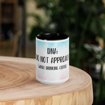 Mug with 'do not approach while drinking coffee' logo on a wooden surface with a blurred background