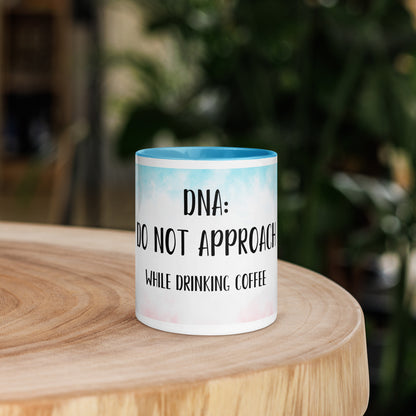 Mug with 'Do not approach while drinking coffee' text on a wooden surface with a blurred green background